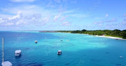 Scenic view of boats in the tranquil Indian Ocean near the beautiful beach on a summer day