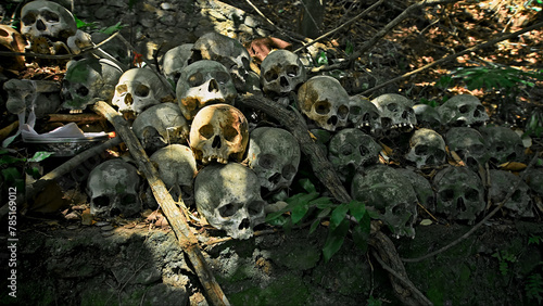 Many green human skulls and bones lying on the ground in the forest, covered in moss in an old abandoned cemetery