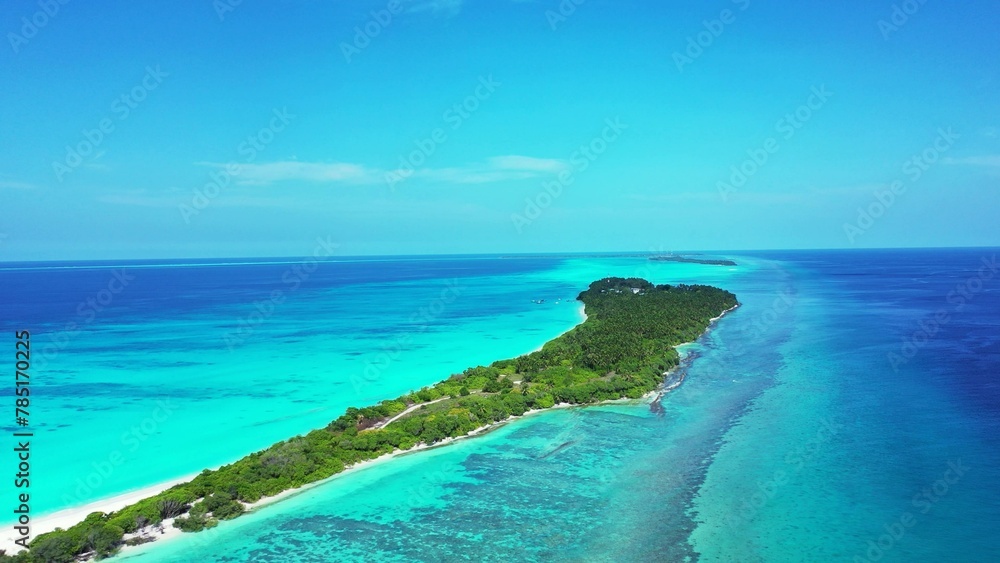 Aerial shot of green island land in the tranquil water in Kuramathi Maldives resort