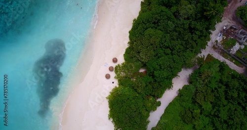 Aerial top view of a small tropical island with a white sandy beach and turquoise water © Wirestock