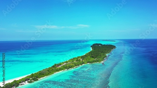 Aerial shot of green island land in the tranquil water in Kuramathi Maldives resort © Wirestock