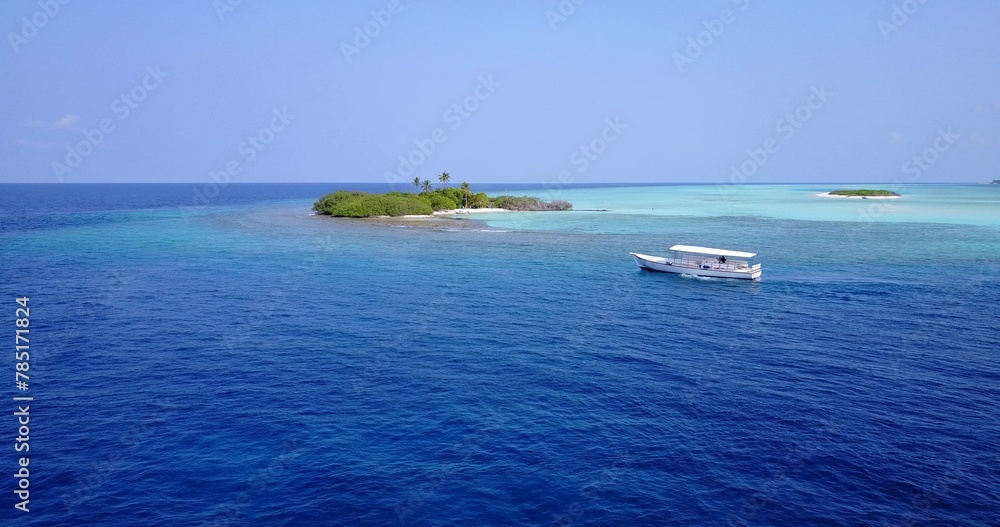 Aerial view of a boat sailing near an island in the Maldives