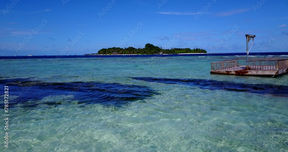 Scenic view of a fishing boat sailing in a tranquil turquoise sea against an island on a sunny day