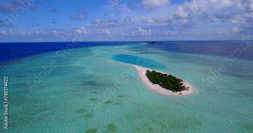 Aerial view of a small tropical island with a white sandy beach and blue transparent water