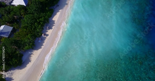 Bird's eye view of the azure water of the ocean and tropical trees in Asia