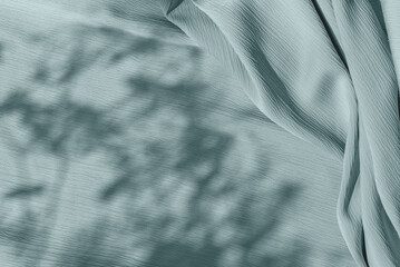 Pastel sage green blue cloth texture with folds and abstract soft floral sunlight shadows, aesthetic neutral background with copy space for wedding design or business branding