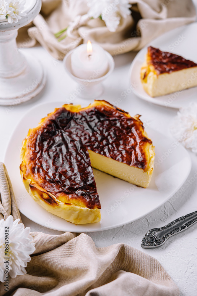 Naklejka premium Traditional basque burnt san sebastian cheesecake slice on elegant table setting