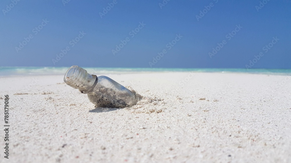 Beautiful view of a small glass bottle on the sand by the sea in Asia Beautiful view of a small glass bottle on the sand by the sea in Asia