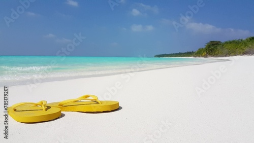Beautiful view of beach slippers on the sand by the sea in Asia