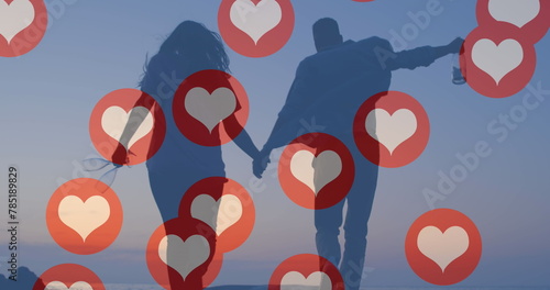 Image of red heart icons floating over couple in love holding hands running