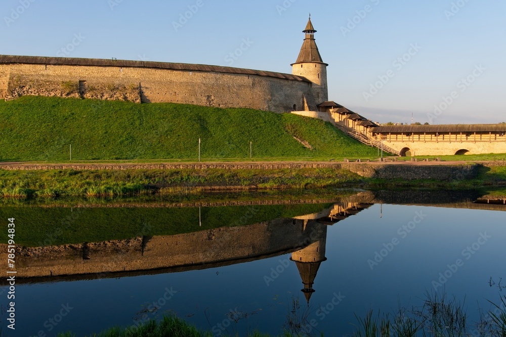 Pskov, Russia, September 11, 2023. Watchtower and fortress wall in the rays of the morning sun.                             