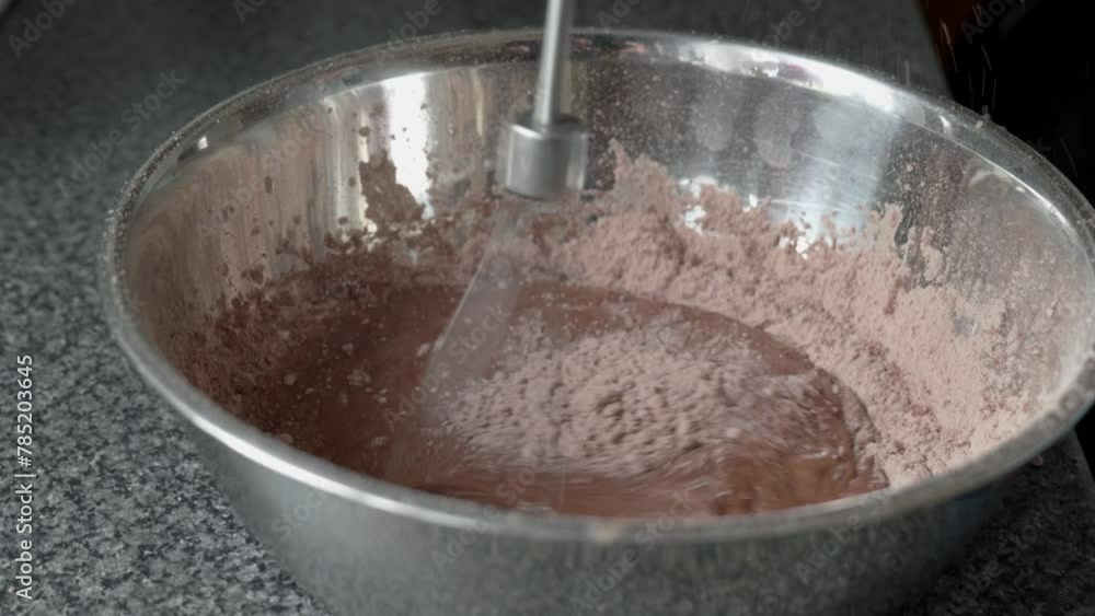 A person is using a kitchen appliance to mix ingredients in a countertop bowl while following a recipe. This cookware and bakeware is essential for preparing dishes in different cuisines at home A person is using a kitchen appliance to mix ingredients in a countertop bowl while following a recipe. This cookware and bakeware is essential for preparing dishes in different cuisines at home