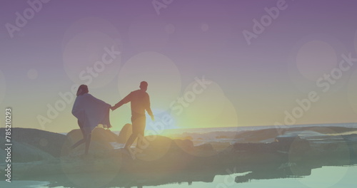 Flares over biracial couple walking on a beach