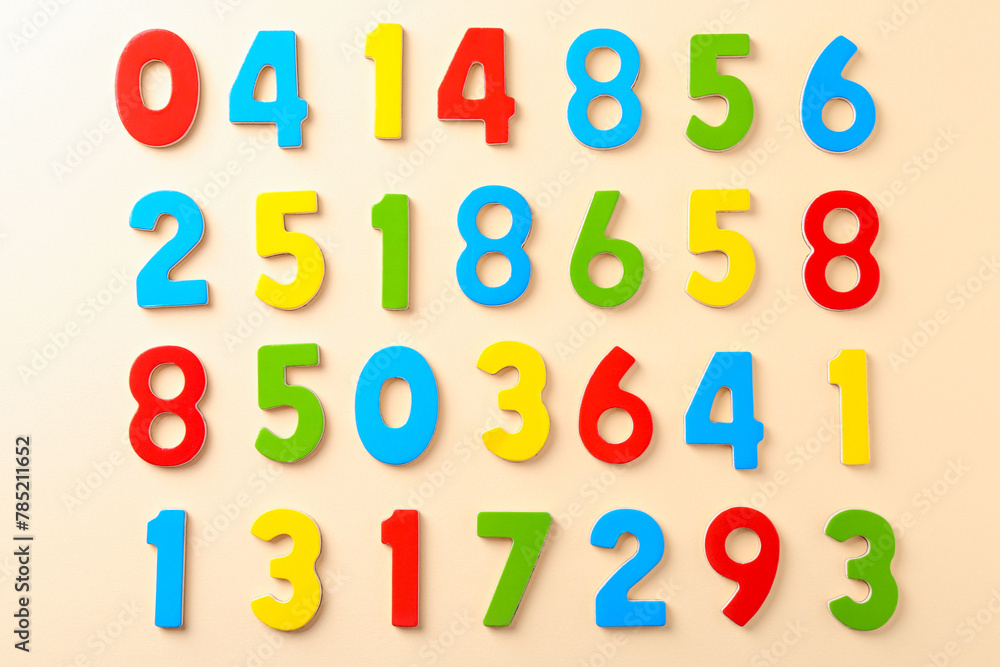 Fototapeta premium Colorful numbers on beige background, flat lay