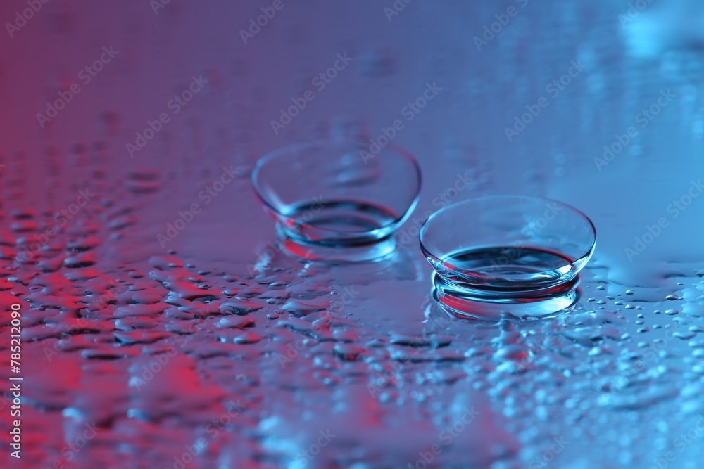 Pair of contact lenses on wet mirror surface. Space for text Pair of contact lenses on wet mirror surface. Space for text
