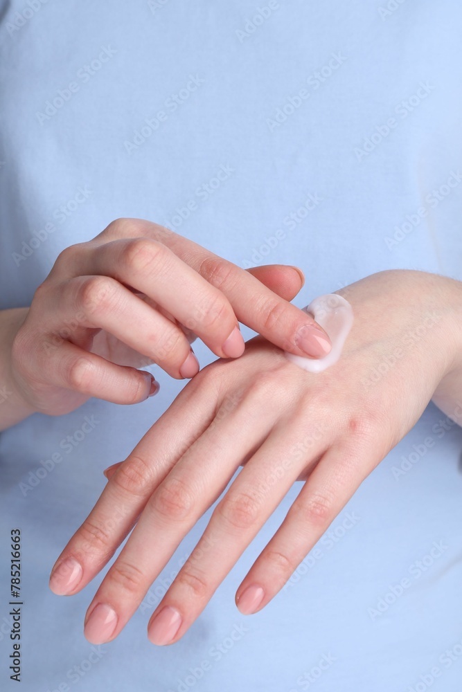 Woman applying cream on her hands, closeup