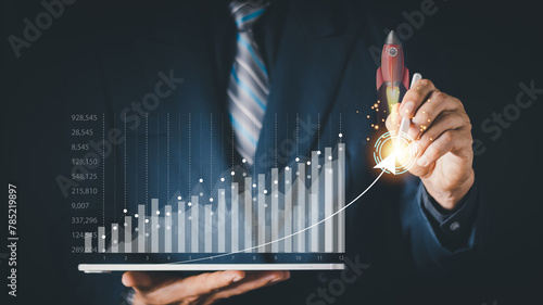 Businessman or merchant showing hologram stock with the direction of rising like a rocket in hand Finance concept, stock market, fast growing business like a rocket.