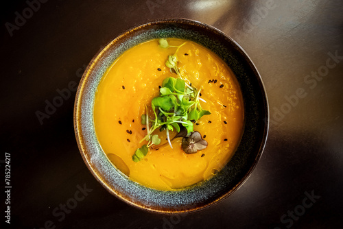 Microgreens on pumpkin soup at a vegan restaurant, elegant healthy dish, shot from the top