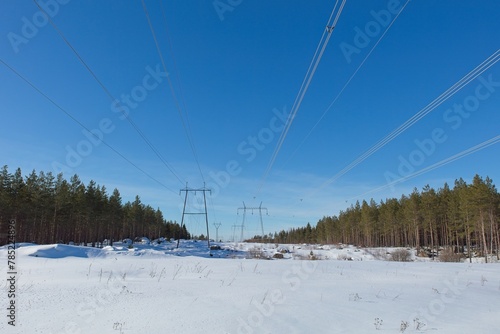 High-voltage power lines in sunny winter weather with snow on the ground, Loviisa, Finland.
