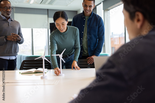 Team of engineers demonstrating wind turbine technology in a meeting photo