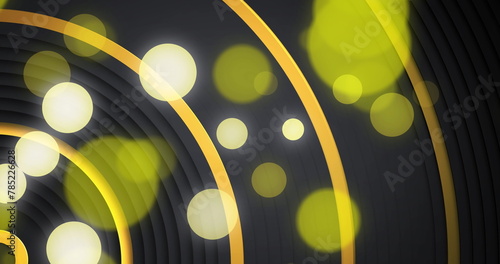Yellow and white bokeh light spots over moving concentric gold curves