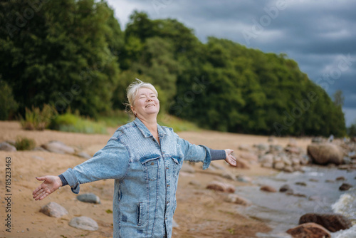 happy senior woman enjoying life and summer on the beach