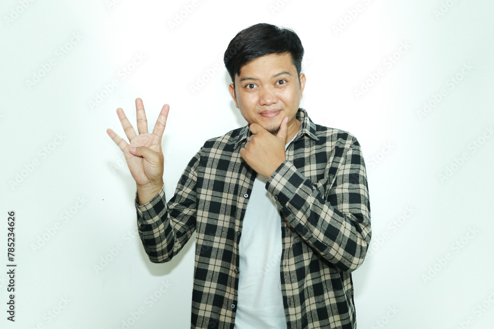 Young Asian man shows a curious facial expression while giving the four finger sign