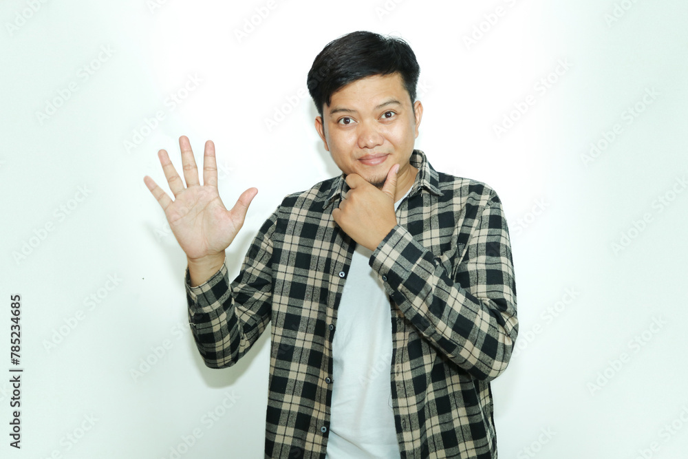 Young Asian man shows a curious facial expression while giving the five finger sign Young Asian man shows a curious facial expression while giving the five finger sign