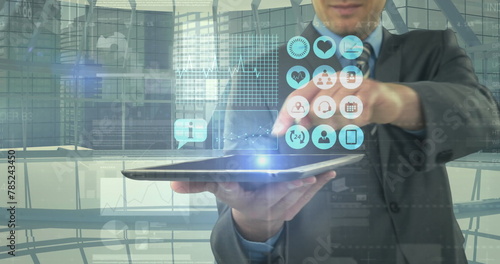 Image of digital icons and financial data processing over businessman holding tablet