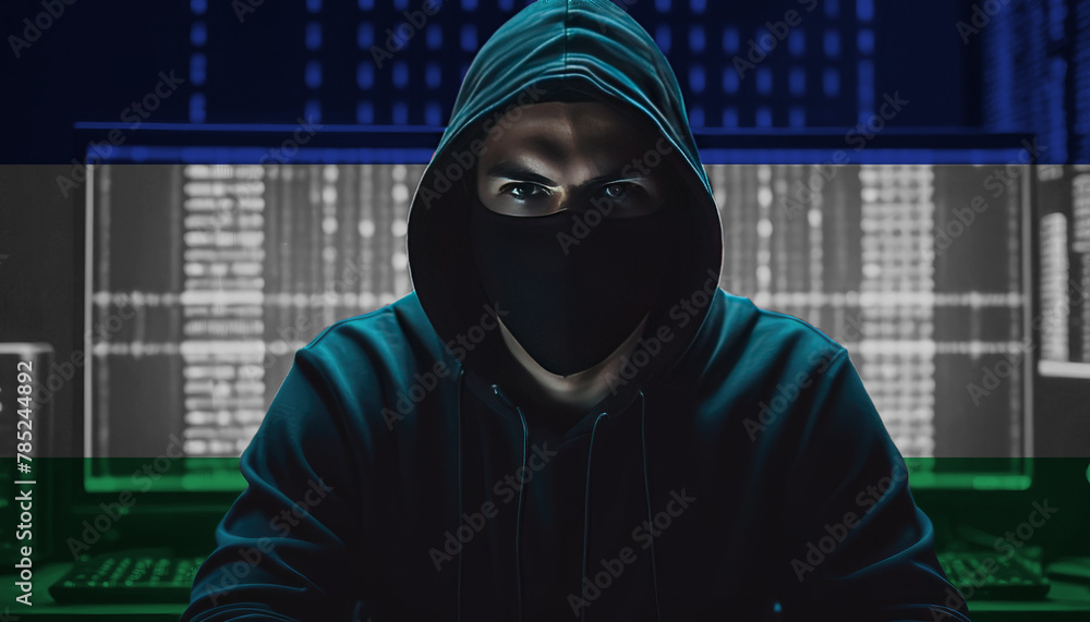 Hacker in a dark hoodie sitting in front of a monitors with Lesotho flag and background cyber security concept Hacker in a dark hoodie sitting in front of a monitors with Lesotho flag and background cyber security concept