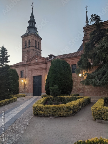 An ancient Catholic church in the historic Spanish town of Navalcarnero in the Madrid region. Religion and culture in Europe. Birds fly over the old Gothic roof against a sky background