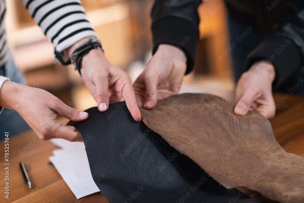 Two female designers selecting between leather and other materials for new furniture design.