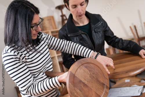 Interior decorator choosing furniture, holding a wooden chair © Microgen