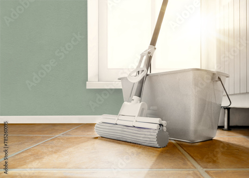 A mop and bucket are on the kitchen floor, wet floor cleaning.