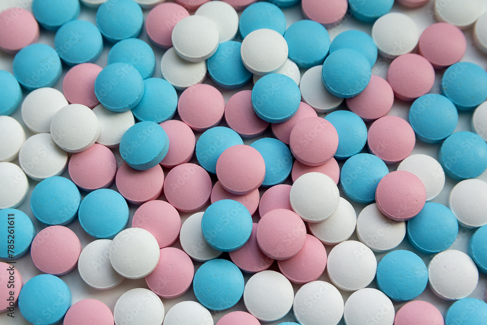 White, blue and pink tablets scattering on the table White, blue and pink tablets scattering on the table