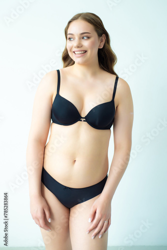 young woman with beautiful hair in black lingerie posing isolated on white background. Model test, snap, polaroid © alipko