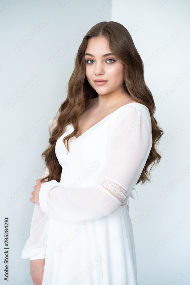 portrait of beautiful young woman in white wedding dress posing in studio. portrait of beautiful young woman in white wedding dress posing in studio.