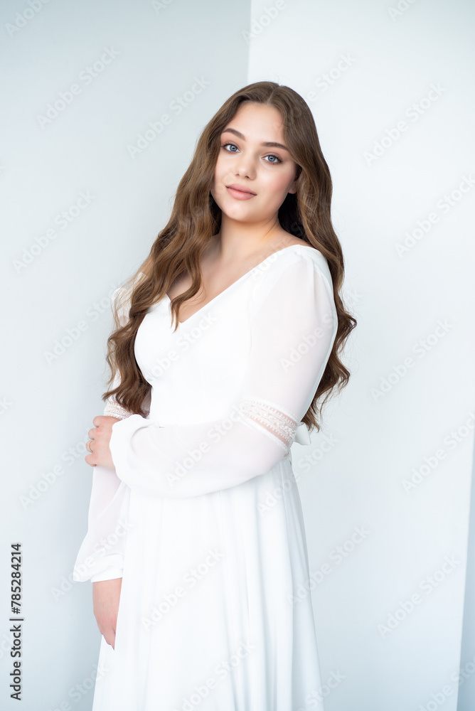 portrait of beautiful young woman in white wedding dress posing in studio. portrait of beautiful young woman in white wedding dress posing in studio.