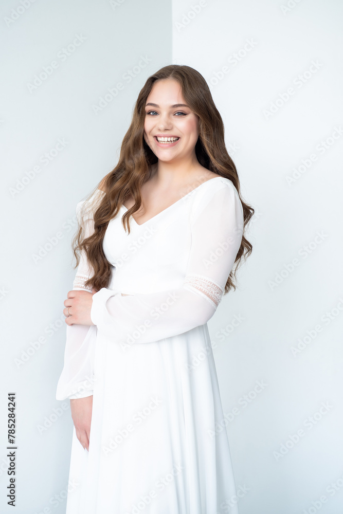 portrait of beautiful young woman in white wedding dress posing in studio. portrait of beautiful young woman in white wedding dress posing in studio.