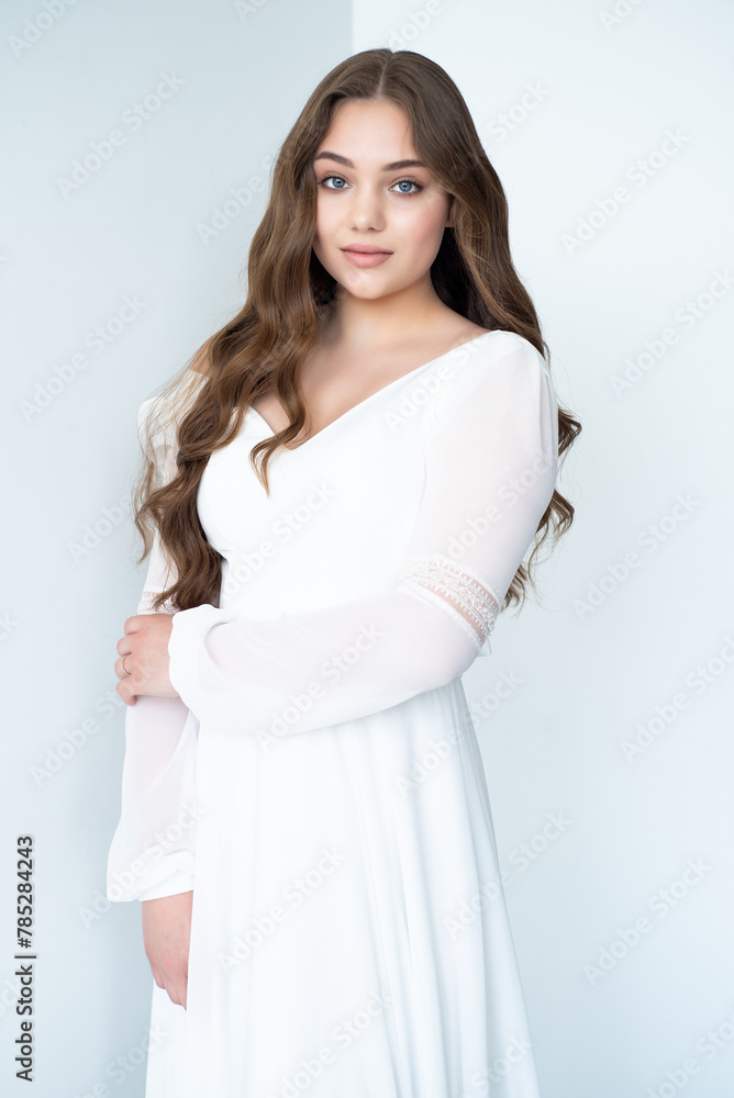 portrait of beautiful young woman in white wedding dress posing in studio. portrait of beautiful young woman in white wedding dress posing in studio.