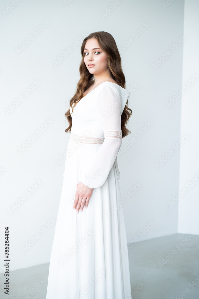 portrait of beautiful young woman in white wedding dress posing in studio. portrait of beautiful young woman in white wedding dress posing in studio.