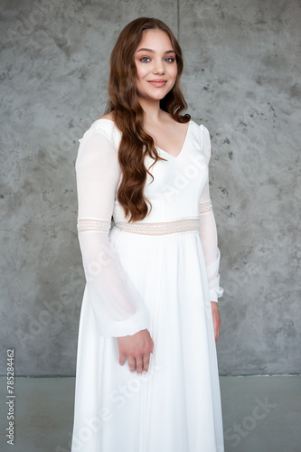 portrait of beautiful young woman in white wedding dress posing in studio. © alipko