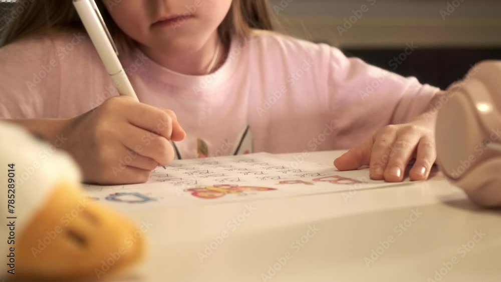 Cute smart preschool 5 years old girl writing homework in exercise copybook, learning letters, sitting at home table. Preparation for school. Home distance education. Children preschool concept. Cute smart preschool 5 years old girl writing homework in exercise copybook, learning letters, sitting at home table. Preparation for school. Home distance education. Children preschool concept.
