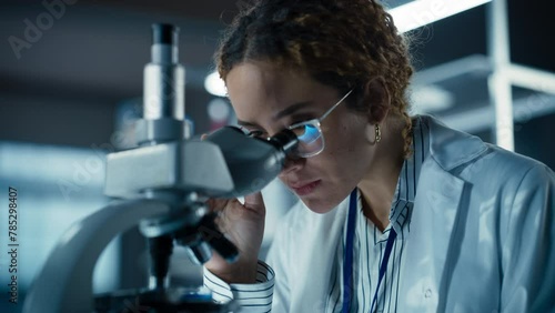 Close Up Portrait of a Multiethnic Student Working on a Research Project in College. Medical Research Scientist Looking at Biological Samples Under a Microscope in an Applied Science Laboratory