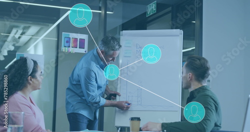 Image of network of connections and icons over business people in office photo