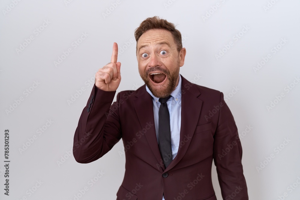 Middle age business man with beard wearing suit and tie pointing finger up with successful idea. exited and happy. number one. Middle age business man with beard wearing suit and tie pointing finger up with successful idea. exited and happy. number one.