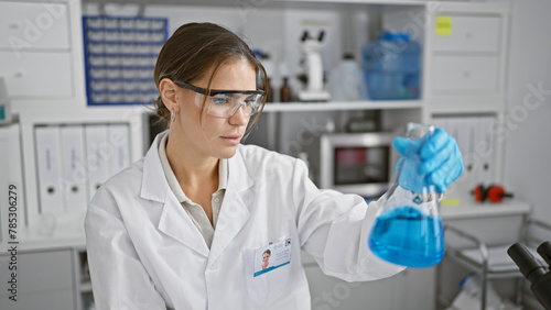 Attractive young hispanic female scientist measuring liquid in a test tube  engrossed in her groundbreaking medical research at the bustling lab  showcasing the beauty of scientific endeavor.