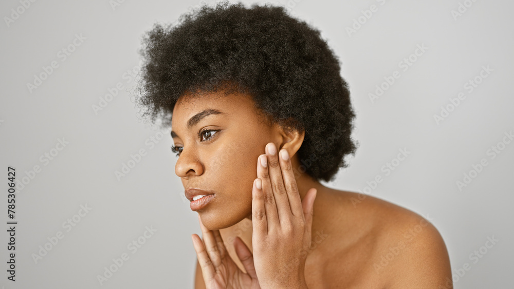 Portrait of a contemplative african american woman with curly hair isolated against a white background, touching her face gently. Portrait of a contemplative african american woman with curly hair isolated against a white background, touching her face gently.