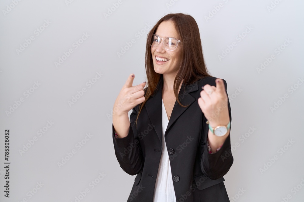 Beautiful brunette woman wearing business jacket and glasses pointing fingers to camera with happy and funny face. good energy and vibes. Beautiful brunette woman wearing business jacket and glasses pointing fingers to camera with happy and funny face. good energy and vibes.
