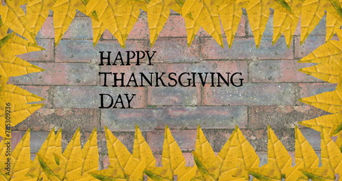 Image of happy thanksgiving day text over bricks with autumn leaves